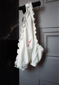 White frill knickers with 'The Mrs.' text hanging on the door handle of hotel bedroom